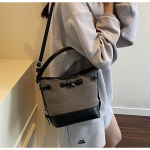 Detail view of retro canvas bucket bag with grey contrast leather strap and drawstring