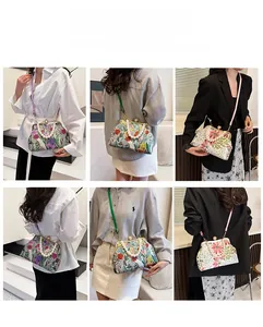 Detail of floral clutch bag featuring pearl handle and multiple carrying styles