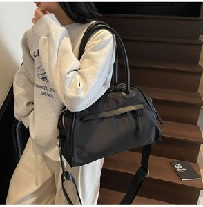 Detail of black nylon Boston bag with leather handles and wide adjustable shoulder strap