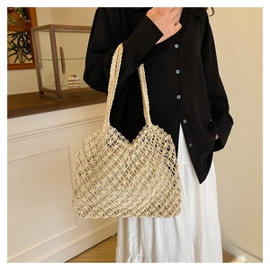 Detail of hand-woven beige tote bag with honeycomb mesh texture and canvas lining
