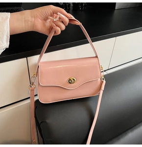 Détail du sac bandoulière en cuir PU rose avec un fermoir rotatif doré de forme ronde