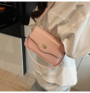 Détail d'un sac à bandoulière en cuir rose avec fermoir rotatif métallique doré chic