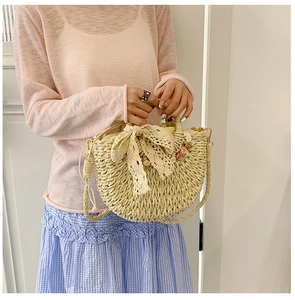 Detail of beige straw bag featuring lace bow and delicate 3D floral appliques