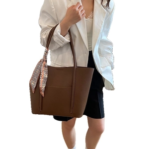 Caramel brown pebbled leather tote bag with silk scarf on a model in white blazer