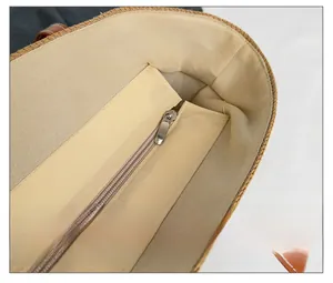 Close-up of smooth metal zipper and beige linen lining inside the straw tote bag
