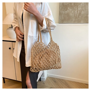 Detail of woven straw tote bag featuring intricate mesh pattern and a drawstring inner pouch