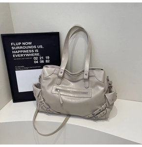 Dettaglio della grande borsa tote beige minimalista con cerniere e cinturini decorativi