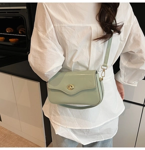 Détail du sac bandoulière vert menthe avec rabat ondulé et fermoir doré sur le modèle