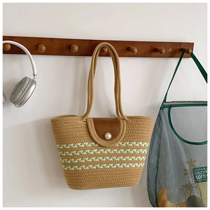 Detail der Sommer Strohtasche mit bunten Streifen, Lederklappe und großer Perle am Verschluss