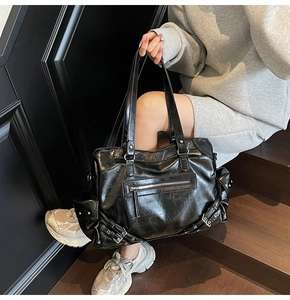 Dettaglio della borsa tote nera lucida con trama stropicciata vintage e rivetti argento
