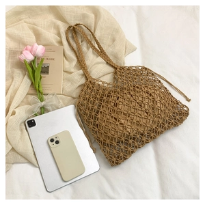 Detail of a brown woven tote bag with a removable drawstring pouch on a natural fabric base