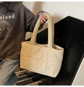 Detailed close-up of cream quilted puffer tote bag with thick padded handles