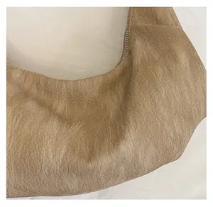 Detailed macro view of soft brown leather texture and zipper on retro dumpling tote bag