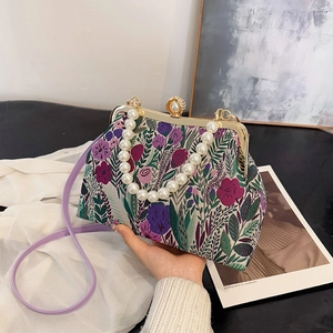 Elegant floral embroidery frame bag with pearl handle and purple crossbody strap