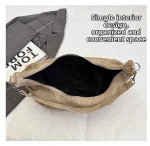 Detail view of the spacious inner compartment and black lining of the brown hobo bag