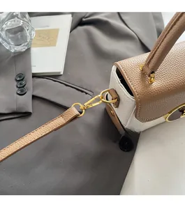 Detailed macro view of litchi grain leather and premium gold metal hardware on handbag