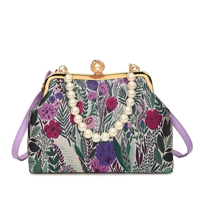 Elegant floral jacquard handbag with pearl handle and golden frame on white background