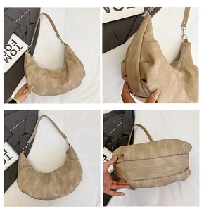 Detail view of large soft faux leather croissant bag with silver zipper and wide strap