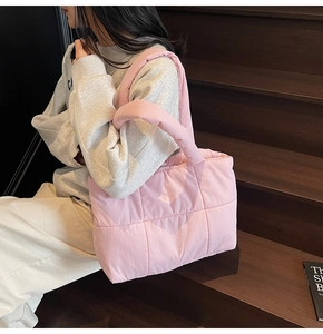 Detail of pink quilted tote bag with padded down material and soft square stitching