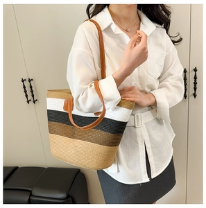 Close-up of woven tote bag with multi-color stripes and brown leather handles