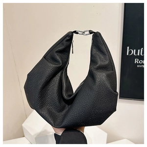 Detail of black hobo bag with lychee grain texture and silver metal chain link