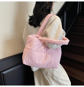 Quilted pink puffer tote bag shown on model highlighting its large size and soft texture