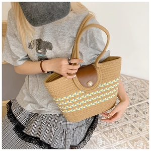 Detail der Retro-Strohtasche mit brauner Lederklappe und elegantem Perlenverschluss-Detail