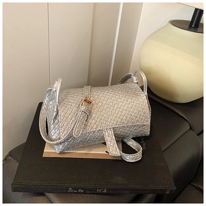 Détail d'un mini sac argenté à texture tissée avec une boucle dorée élégante