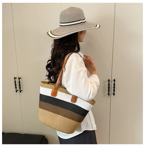 Detail of multi-color striped straw tote bag and matching hat with brown leather handles