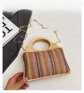Detalle del bolso de paja con ondas de colores, asa redonda de madera y cadena dorada