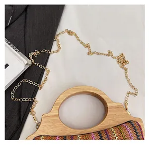 Detalle de bolso de paja a rayas con asa de bambú y correa de cadena dorada de alta calidad