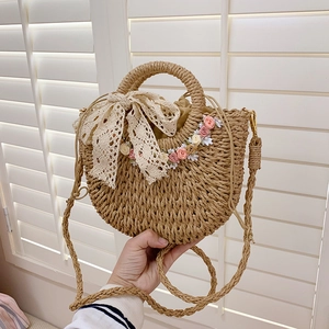 Handwoven straw basket bag with lace bow and floral accents for summer fashion