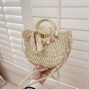 Handmade beige straw tote bag with lace bow and floral accents for summer vacation