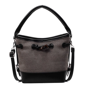 Minimalist canvas bucket bag with black leather trim and adjustable crossbody strap