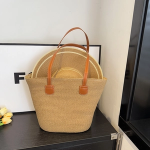 Detail of hand-woven straw tote with leather handles and matching summer beach hats