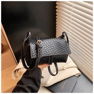 Détail du sac bandoulière noir tissé avec fermoir doré et fine lanière élégante