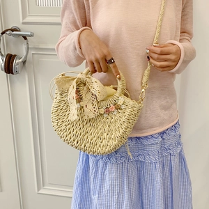 Semicircle straw bag with lace bow and floral accents, crossbody and top handle design