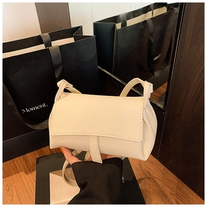 Close-up of beige quilted leather crossbody bag with flap and slim strap details