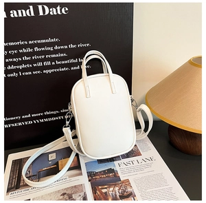 Detail view of cream PU leather mini crossbody bag with sleek metal hooks and dual handles