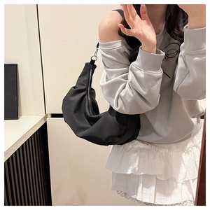 Close-up of black soft leather hobo bag with natural folds and silver zipper detail