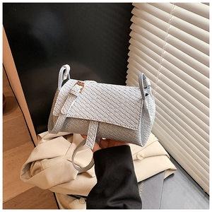 Détail de la texture tissée bleu clair et du rabat d'un petit sac à bandoulière chic