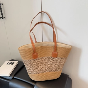 Detail view of woven tote bag with three-tone stitch textures and brown leather handles