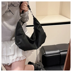 Detail of black leather hobo bag with silver zipper and textured soft leather finish