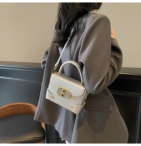 Detail view of silver lychee texture bag with gold twist lock and elegant rivets