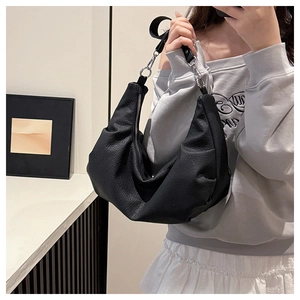 Detail of soft leather dumpling bag showing silver rings and adjustable shoulder strap