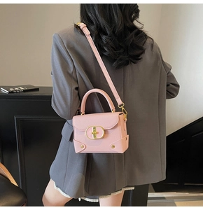 Pink lychee texture leather handbag with gold oval lock and bottom rivets detail