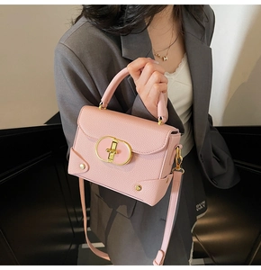 Detail of pink crossbody bag with cross-grain leather texture and gold oval lock