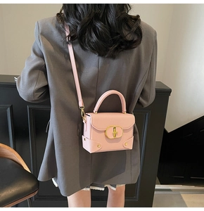 Pink lychee grain leather handbag with gold twist lock shown on model's shoulder
