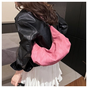 Close-up of pink soft leather crescent bag with zipper closure and natural fold details