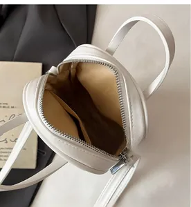 Top view detail of the white mini bag interior featuring khaki lining and side pocket